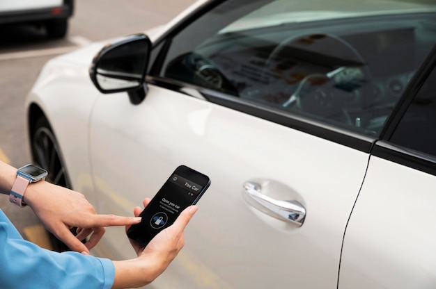 Mão usando o telefone para desbloquear o carro