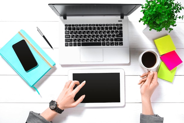 Mão use tablet branco na vista superior da mesa de trabalho. Copie o espaço. Postura plana