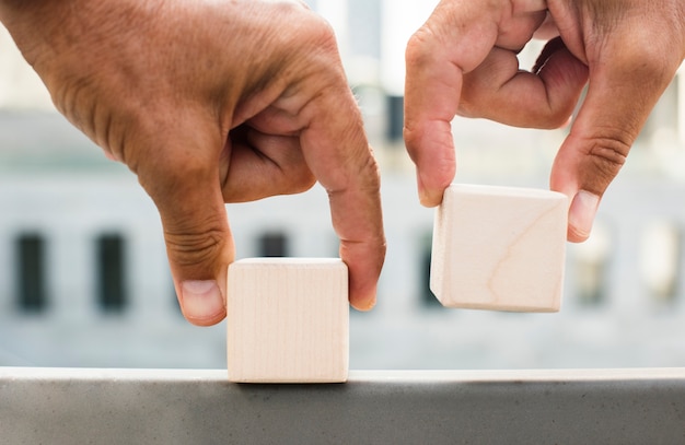 Mãos colocando cubos na superfície