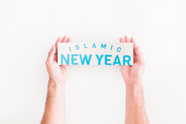 Mãos com papel islâmico de ano novo