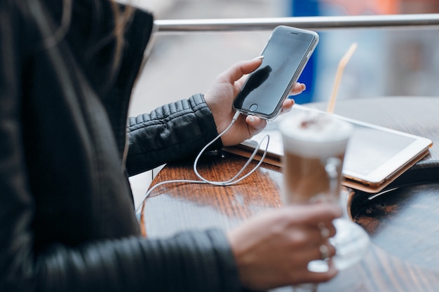 Mãos da mulher olhando para um telefone móvel