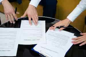 Foto grátis mãos de alto ângulo assinando documentos