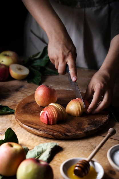 Mãos de alto ângulo cortando maçã