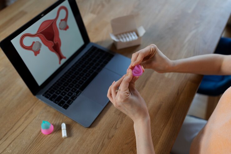 Foto grátis mãos de alto ângulo dobrando o copo menstrual