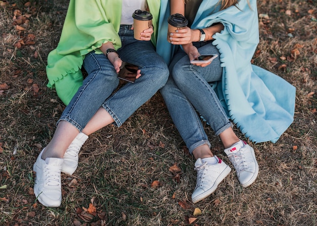 Mãos de alto ângulo, segurando os telefones e copos de café