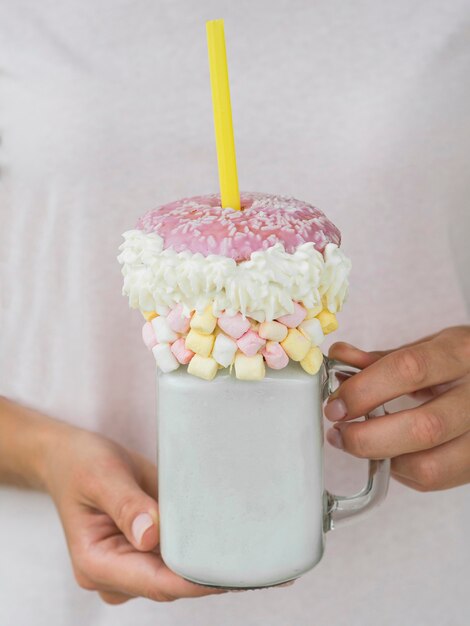 Mãos de close-up, segurando o frasco de milkshake