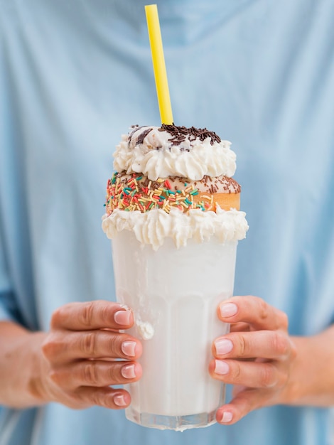 Mãos de close-up, segurando o milk-shake