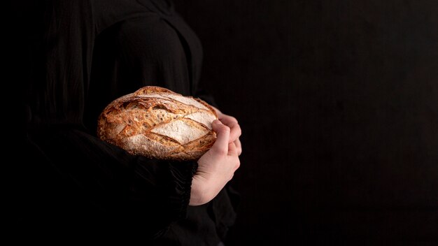 Mãos de close-up, segurando o pão saboroso
