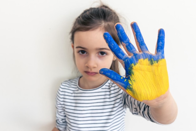 Mãos de criança pintadas nas cores da bandeira da ucrânia