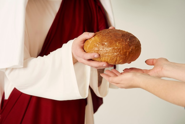Mãos de cristo entregando pão Foto Premium
