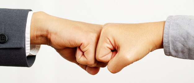 Mãos de dois empresários usam fazer um punho fechado após um bom negócio. sucesso e mostrar poder de força do conceito de trabalho em equipe.