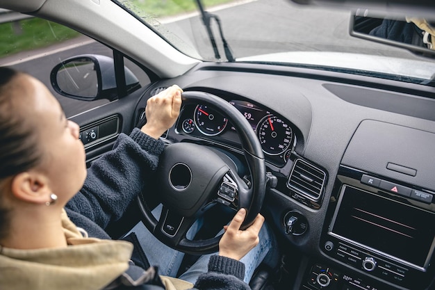 Foto grátis mãos de motoristas de mulher em um volante de carro