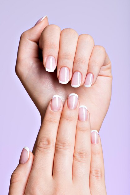 Mãos de mulher bonita com lindas unhas depois de salão de manicure com manicure francesa