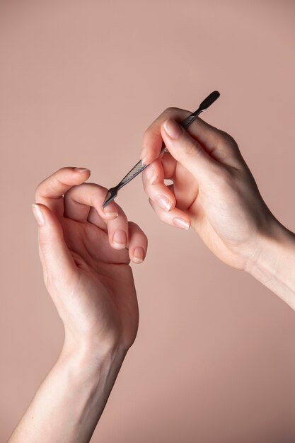 Mãos de mulher com produto para cuidar das unhas