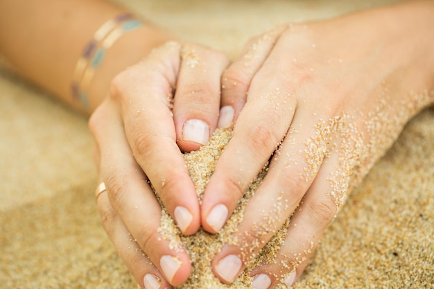 Mãos de mulher com tatuagem de adesivo na areia