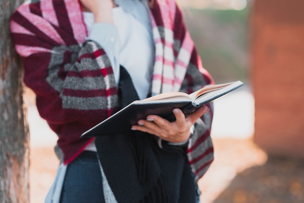 Foto grátis mãos de mulher de close-up segurando um caderno