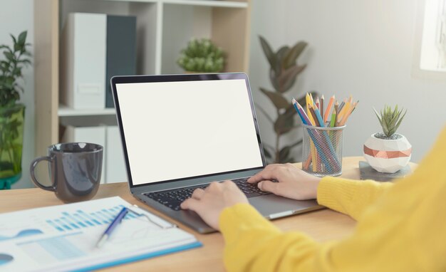 Mãos de mulher de negócios usando laptop com tela em branco. Mock-up do monitor do computador. Copyspace pronto para desenho ou texto.
