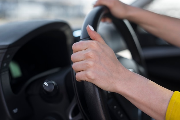 Mãos de mulher segurando o volante