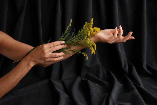Mãos de mulher segurando uma planta amarela