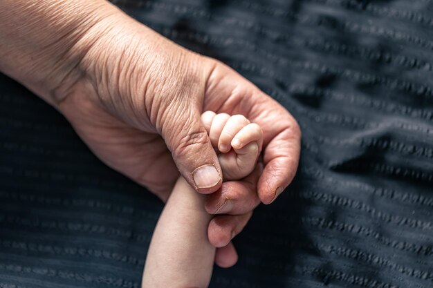 Foto grátis mãos de pessoa sênior e bebê fecham