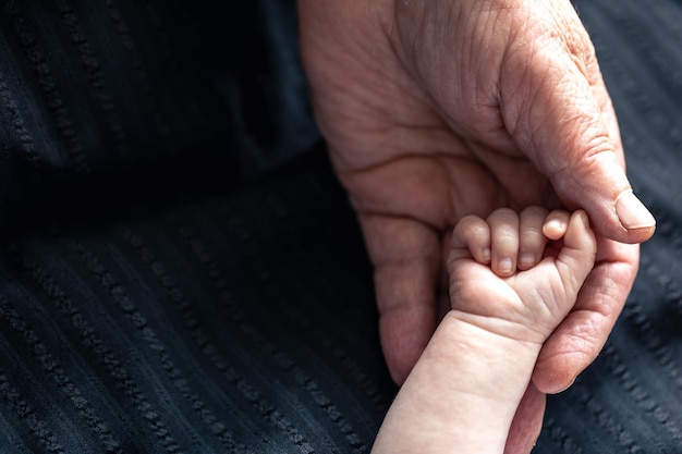 Foto grátis mãos de pessoa sênior e bebê fecham