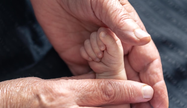 Foto grátis mãos de pessoa sênior e bebê fecham