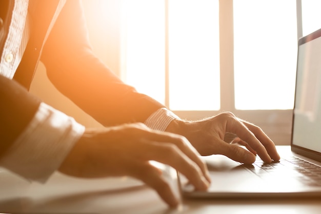 Mãos de um empresário usando laptop na internet