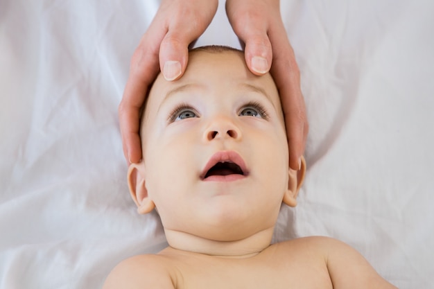 Foto grátis mãos de uma mãe cabeça tocante de seu bebê