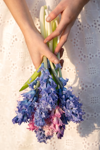 Foto grátis mãos de vista frontal segurando lindas flores