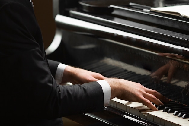 Mãos de vista lateral tocando piano