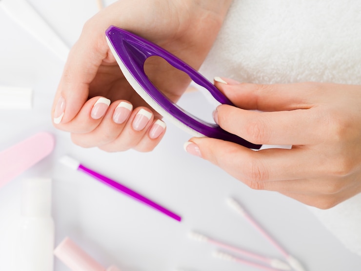 Foto grátis mãos de vista superior usando ferramentas de manicure