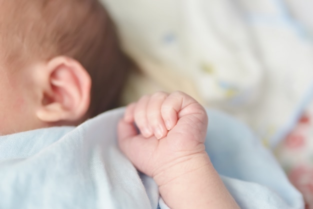 Mãos do bebê. A criança suga punhos