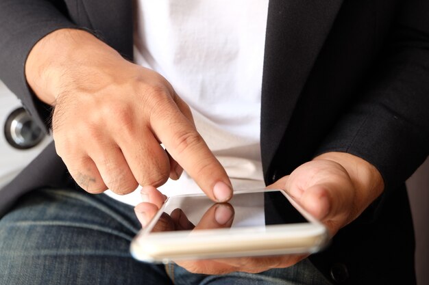 Mãos do homem asiático usando o telefone inteligente, conceito de mídia social