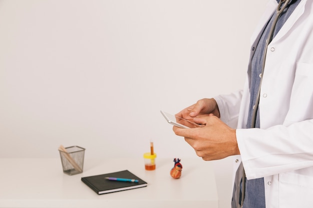 Foto grátis mãos do médico com o telefone