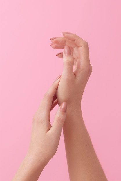 Foto grátis mãos do modelo com fundo rosa