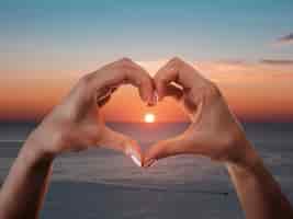 Foto grátis mãos em forma de coração em um pôr do sol