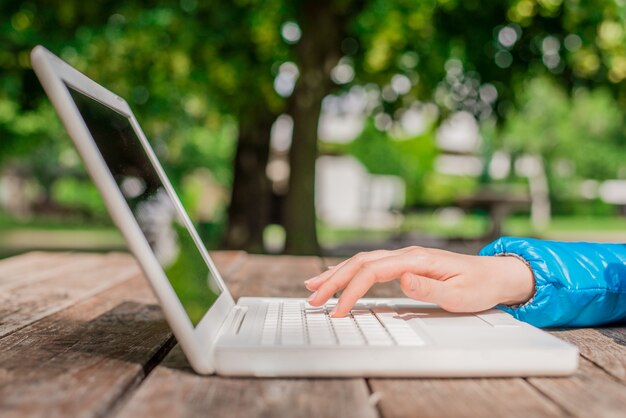 Mãos estudantis com laptop. Relaxando no parque usando o laptop. Conceito de escritório ao ar livre, close up business woman é um laptop de uso para o trabalho, pesquisando web, navegando informações.