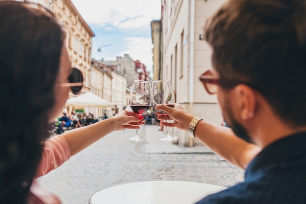 Mãos fechadas de casal brindando taças de vinho