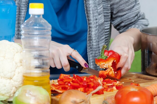 Mãos femininas corta pimenta