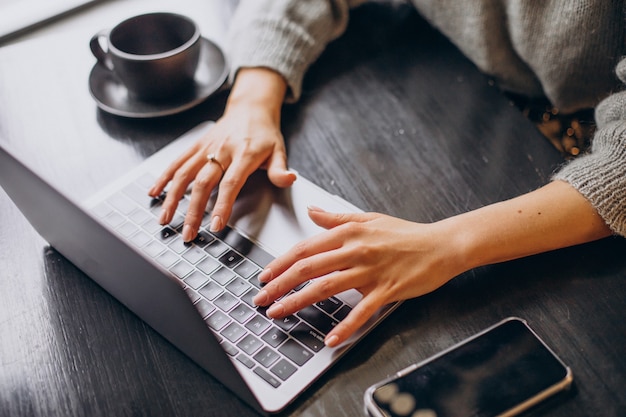 Mãos femininas digitando no teclado do computador