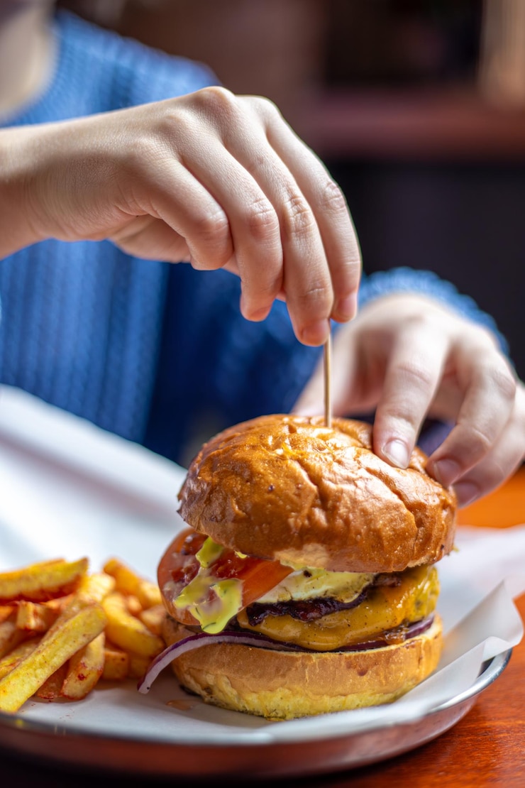 Foto grátis mãos femininas segurando um hambúrguer fast food trapaça refeição hambúrguer closeup