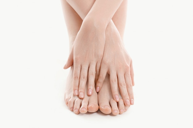mãos femininas sobre os pés, conceito de cuidados da pele