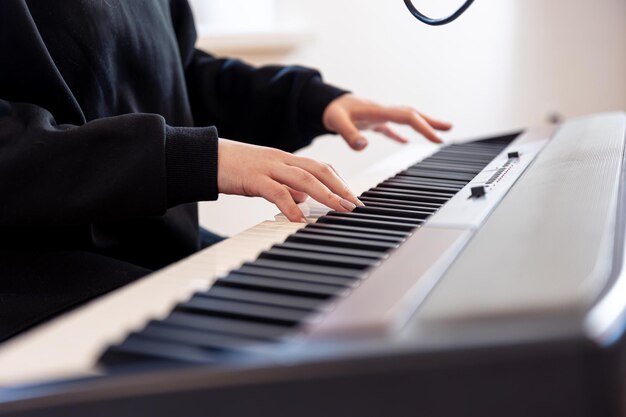 Mãos femininas tocam teclas musicais com foco suave