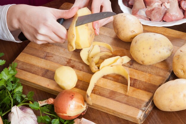 mãos limpando batatas