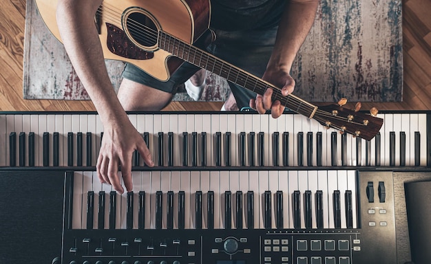 Mãos masculinas na vista superior das teclas de piano