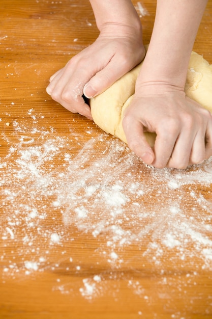 Mãos que amassam a massa de pão