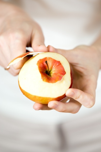 Foto grátis mãos que descascam uma maçã