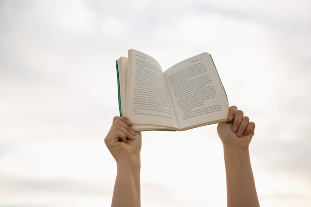 Foto grátis mãos que prendem o livro aberto