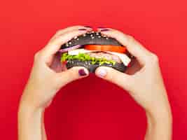 Foto grátis mãos, segurando, apetitoso, hambúrguer, com, experiência vermelha