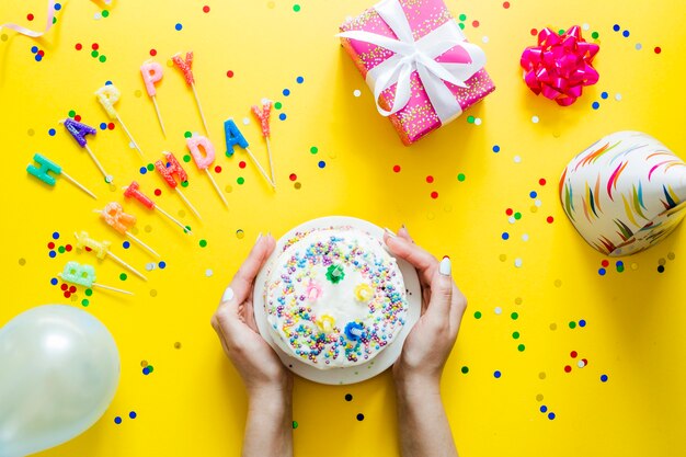 Mãos segurando bolo de aniversário caseiro